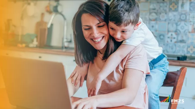 À esquerda degradê laranja. Ao fundo, criança abraçando mulher mexendo no computador. No canto inferior direito, o logotipo da FM2S.